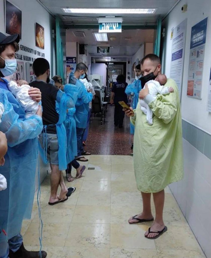 3אבות מחזיקים את התינוקות שלהם במסדרון ממוגן בבית החולים ברזילי באשקלון